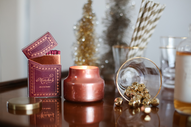 holiday candles and jingle bels on a styled table